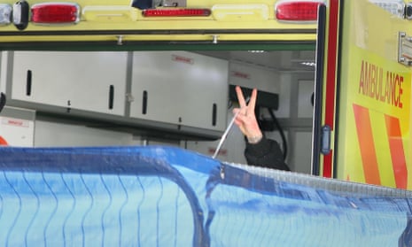 The final activist to leave the tunnel gestures from an ambulance.