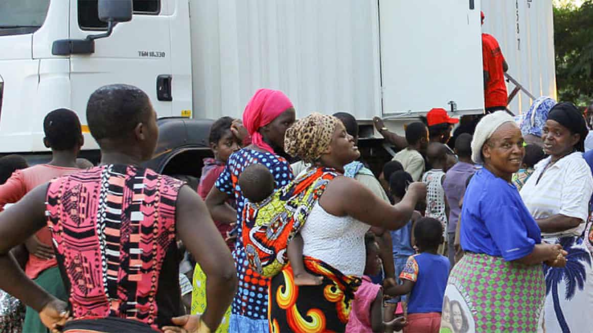 People line up outside a screening truck