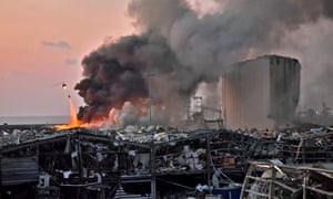 A helicopter puts out a fire at the scene of an explosion at the port of Lebanon’s capital Beirut on 4 August 2020.