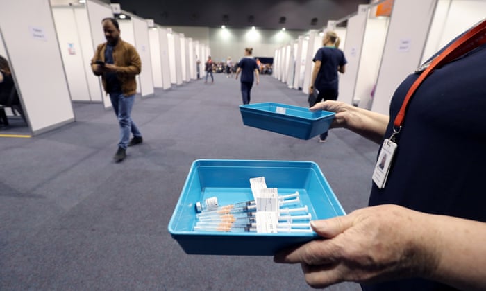 A health worker holds a tray of syringes with the Pfizer vaccine on the opening day of a Covid-19 mass vaccination clinic in Perth on 16 August 2021.