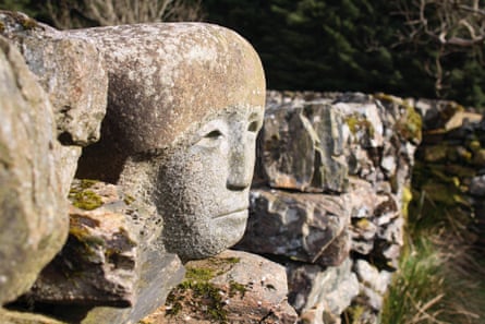 A carved face emerges from a stone wall