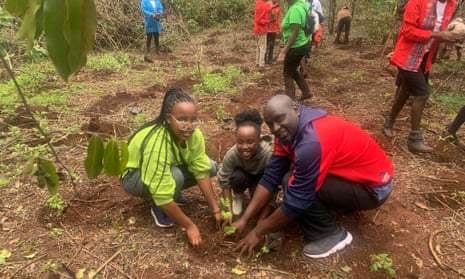Geoffrey Mosoku planting a tree with his daughters.