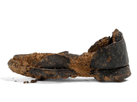 A decomposing shoe against a white backdrop