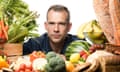Dr Chris van Tulleken surrounded by fruit, vegetables and wholemeal bread.