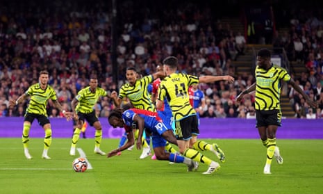 Crystal Palace's Eberechi Eze goes down in the penalty area under the challenge from Arsenal’s Declan Rice and Thomas Partey (right) during the Premier League match at Selhurst Park, London.