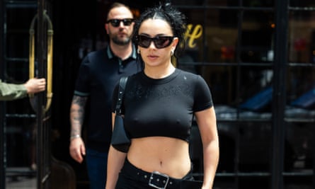 person wearing black crop T-shirt, black belt and sunglasses