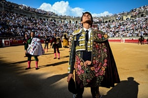 A matador closes his eyes and looks to the sky in a packed bullring