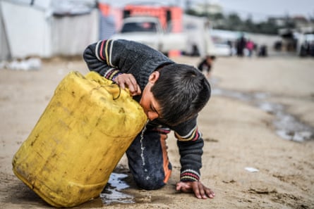 a child drinks water from a dirty plastic container