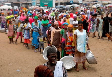 People wait to receive food and water from volunteers in Accra during the partial lockdown on 4 April.