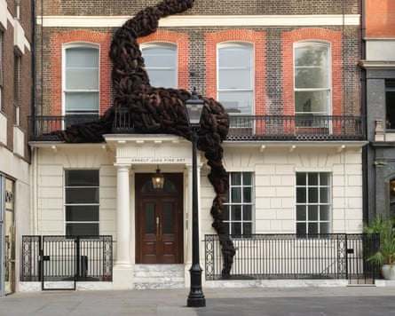 The outside of Annely Juda is shown with an enormous growth of hair climbing the wall, seemingly growing out from within the gallery