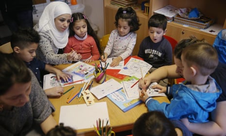 Refugee mothers and children look through games and books in another initiative by the German education ministry, the reading start for refugee children. 