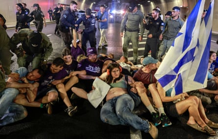 Israeli police remove people sitting on the road