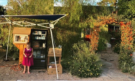 Kim Foster’s daughter, Desi, stands by the family’s Little Free Library and the community fridge that provided goods to their Las Vegas neighbors.