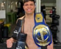 Sharif Ahmadzai with boxing belts and gloves slung across his shoulder