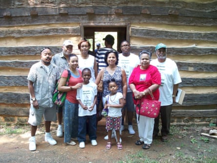 Several members of the Quander family pose in front of a cabin