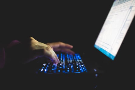 Close-up photograph of a woman’s hands working on a laptop