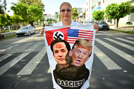 a woman holds a protest sign in the street