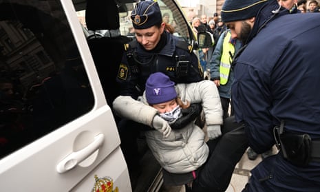 Swedish police carry Greta Thunberg into a police van