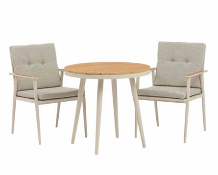 Two light grey wooden chairs. Each chair has a grey seat cushion and a grey back rest cushion with two buttons. In front of the chairs is a light grey four-legged table with a wooden top
