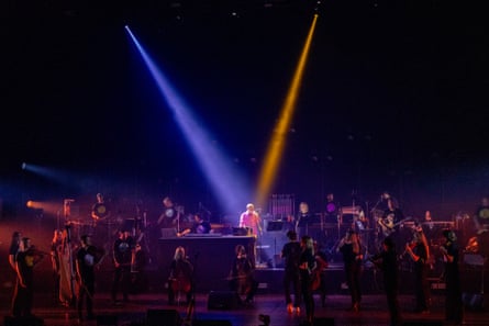 ‘At the centre of the dark stage is Eno himself in a pink jacket, like a beating heart.’