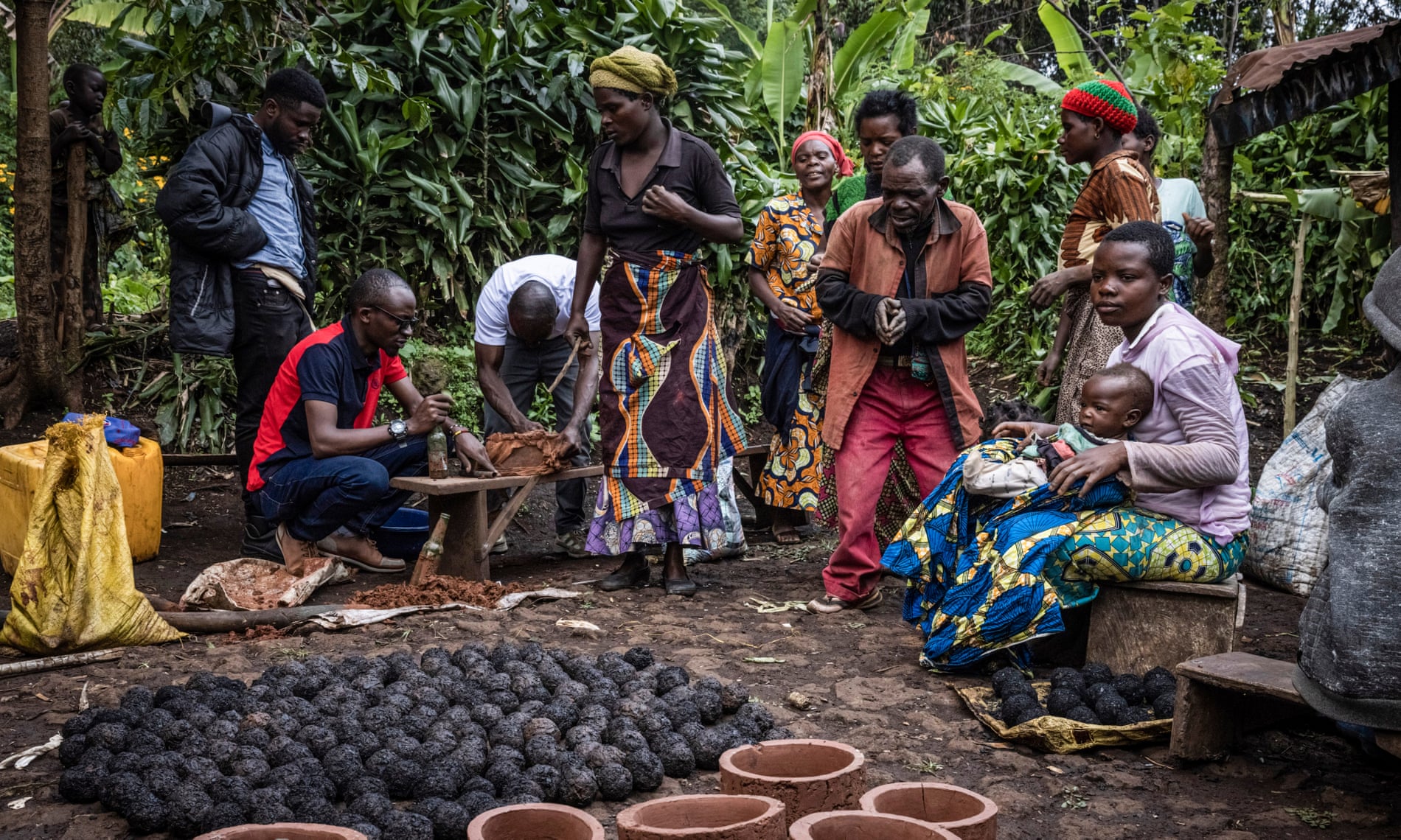 Biologist Cédric Muliri works with Batwa community members in Chibuga village to make fuel efficient stoves