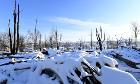 Charred trees surround the snow-covered remains of homes destroyed by the Marshall Fire in the Rock Creek neighborhood of Superior in Boulder county, Colorado.