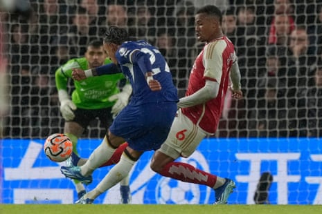 Chelsea's Malo Gusto kicks the ball in an attempt to score as Arsenal's Gabriel Magalhaes attempts to block.