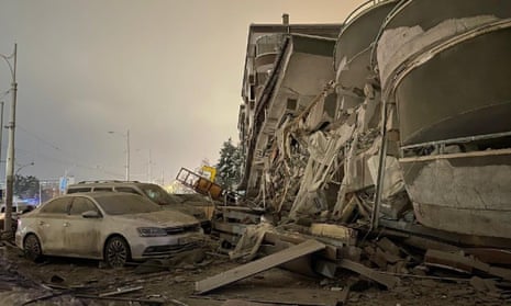 A fallen building and car covered in debris after the 7.8 magnitude quake in Turkey