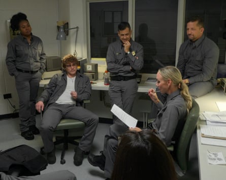 A group of people in matching grey outfits sitting and standing in a room