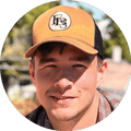 A man in a hat smiles outside