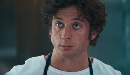 Wearing whites and an apron, he stares bemusedly into the distance