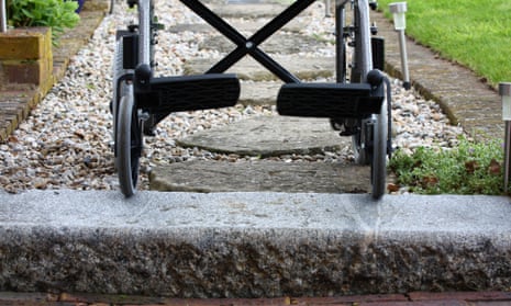 A wheelchair on stone steps and gravel.