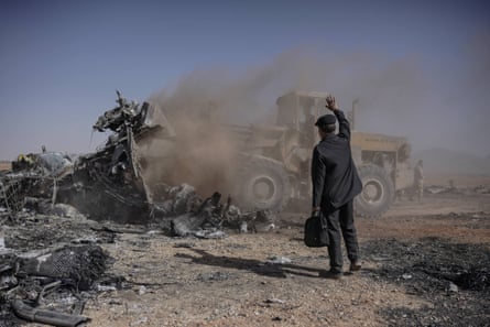 A bulldozer clears the burned aircraft