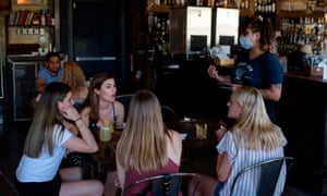 A server wearing a facemask takes orders from a table of customers at Eight Row Flint in Houston in May.