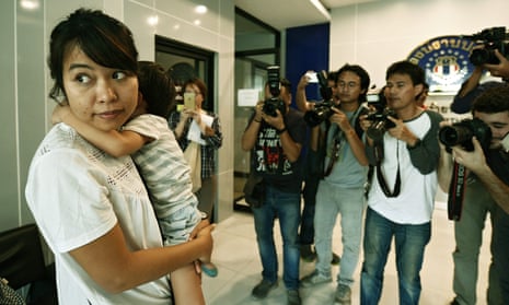 Noppawan Bunluesilp arrives at a police station in Bangkok with her three-year-old son.