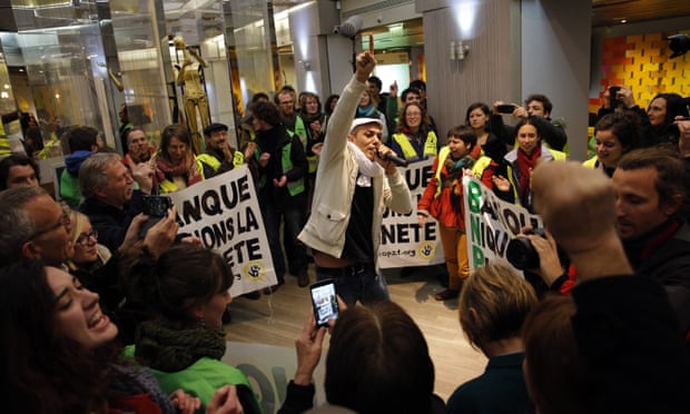 Activists sing and dance during a concert in a BNP Paribas bank they occupied in Paris on 9 Dec during the climate summit