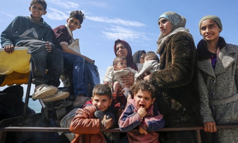 Palestinian refugees displaced after Israeli attacks in Gaza on the back of a pick-up truck