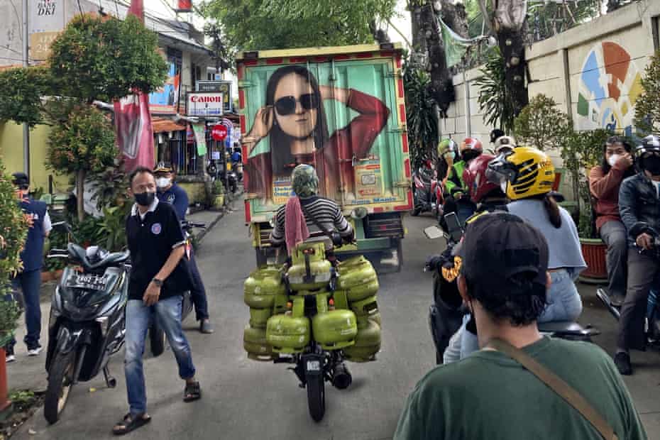 People make their way through a crowded street in Jakarta, Indonesia