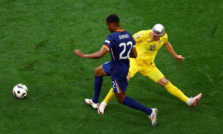 Denzel Dumfries goes past Romania’s Ianis Hagi