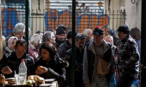 Greek people queue to enter a soup kitchen run by the Orthodox church in Athens.