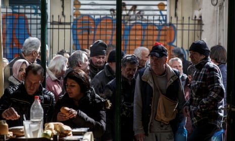 Greek people queue to enter a soup kitchen run by the Orthodox church in Athens. 
