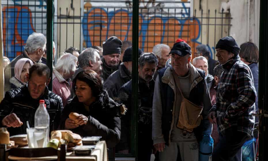 People queue to enter a soup kitchen run by the Orthodox church in Athens