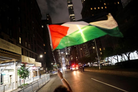 A person waves a Palestinian flag during a protest against Israeli prime minister Benjamin Netanyahu prior to his arrival to a hotel in Manhattan.