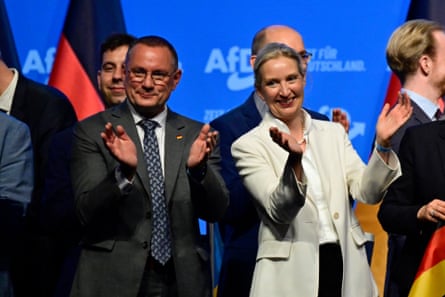 AfD co-leaders Alice Weidel (R) and Tino Chrupalla applaud after singing the national anthem at the end of their party congress in Erfurt, eastern Germany on July 5, 2026.
