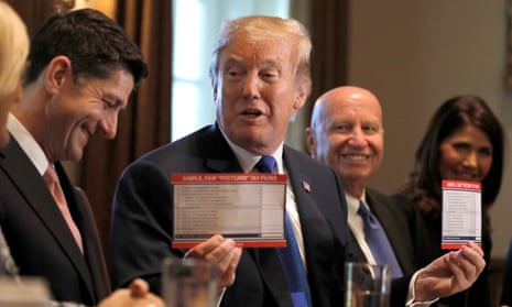 President Trump holds sample tax forms as he promotes his tax plan at the White House in Washington.