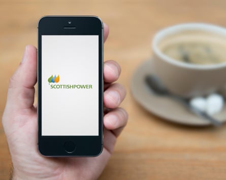 A man looks at his iPhone which displays the Scottish Power logo