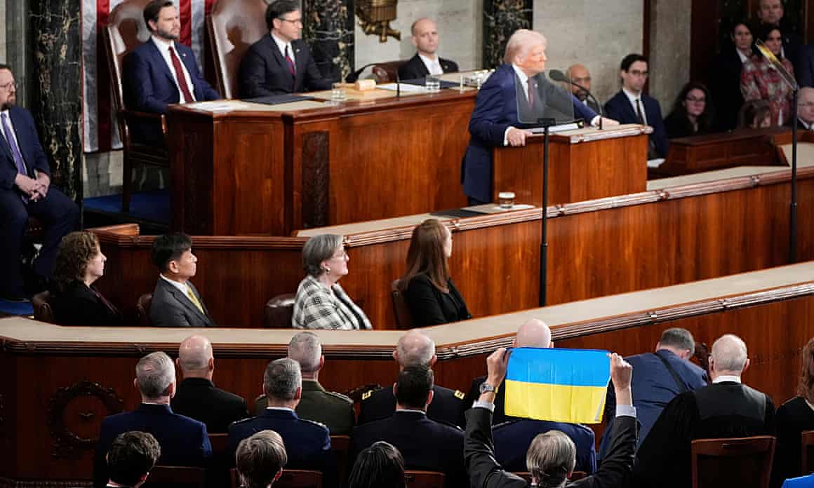 A member of Congress holds up Ukraine’s flag as President Donald Trump addresses a joint session of Congress at the Capitol in Washington.