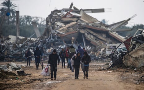 Palestinians walk among the rubble left in the Gaza Strip by Israeli military action.