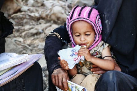 A child eats from what appears to be a USAID ration pack
