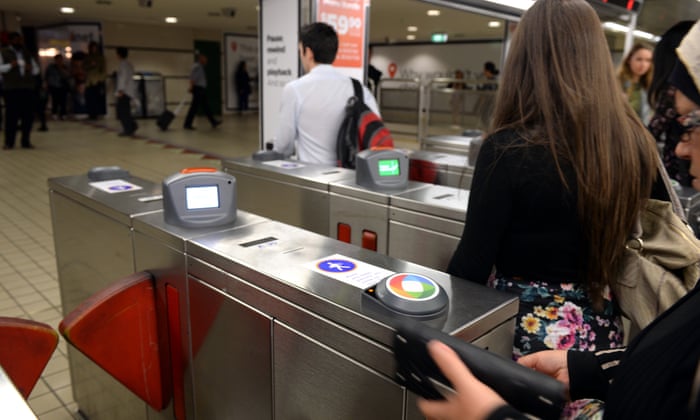 Commuters rush through an Opal reader gate at a NSW train station